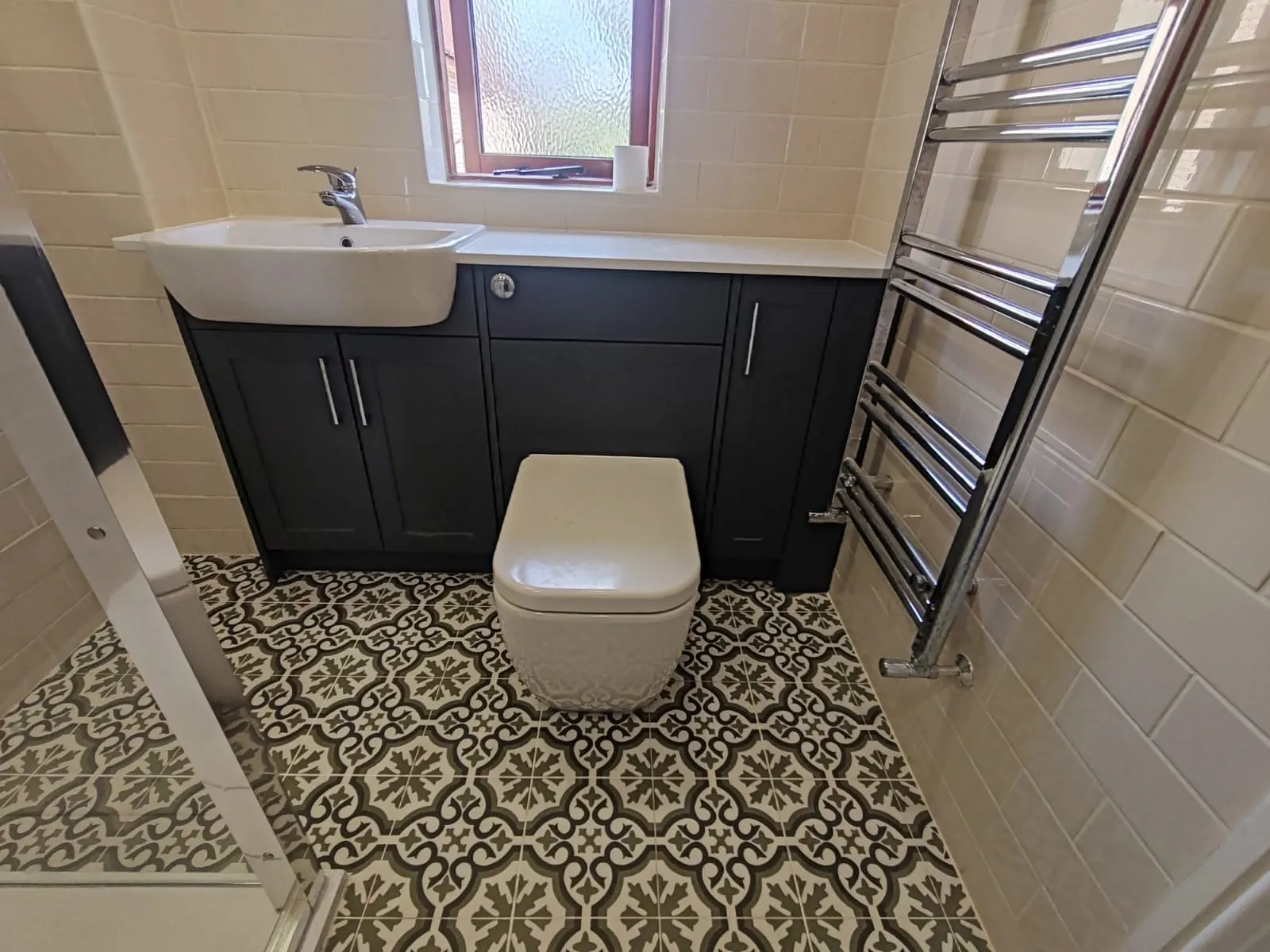 A well-lit bathroom containing a sink, toilet, and shower, emphasizing a simple and organized design