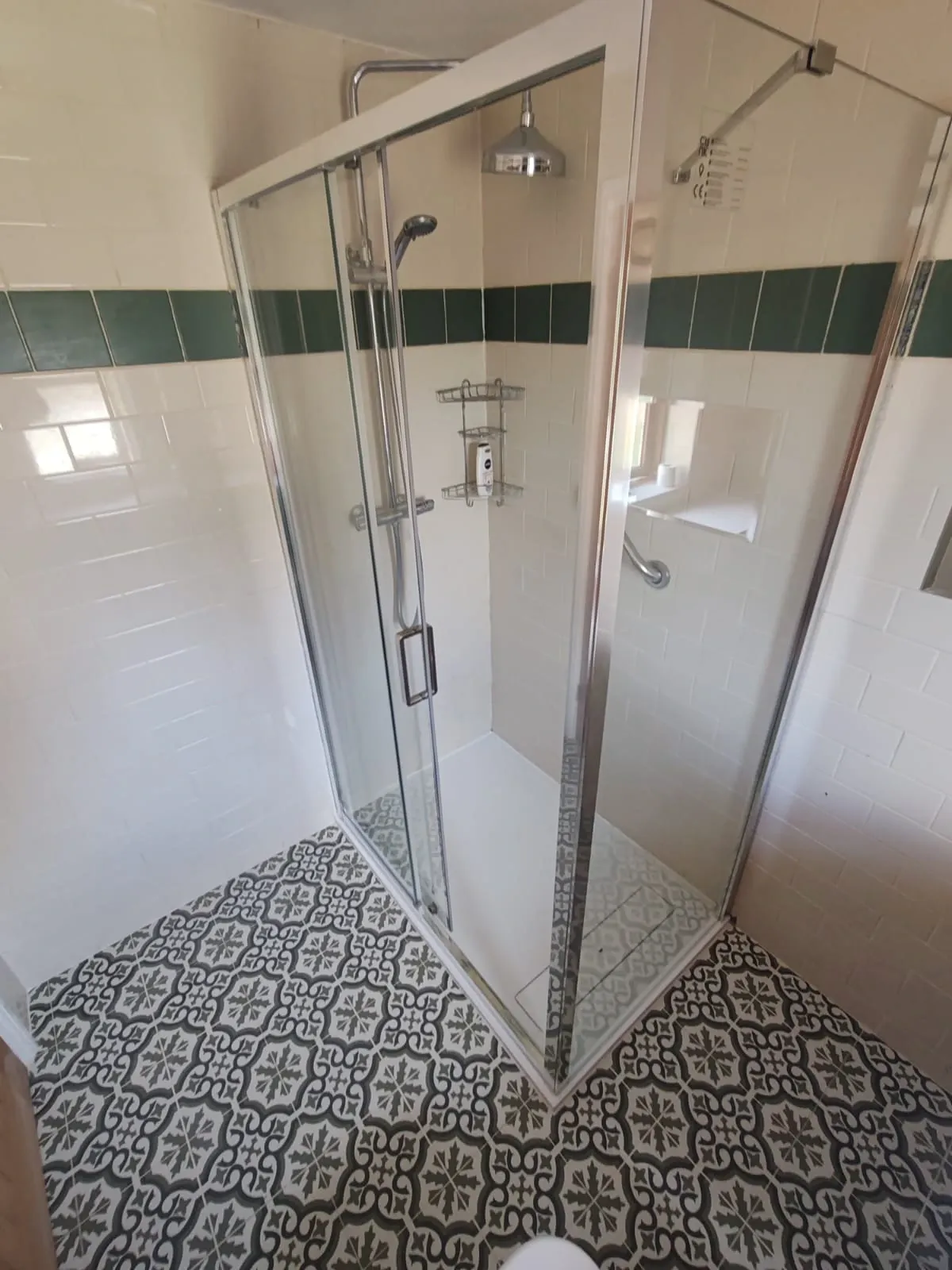 A well-lit bathroom with a shower and elegant tile floor, highlighting a fresh and inviting atmosphere.