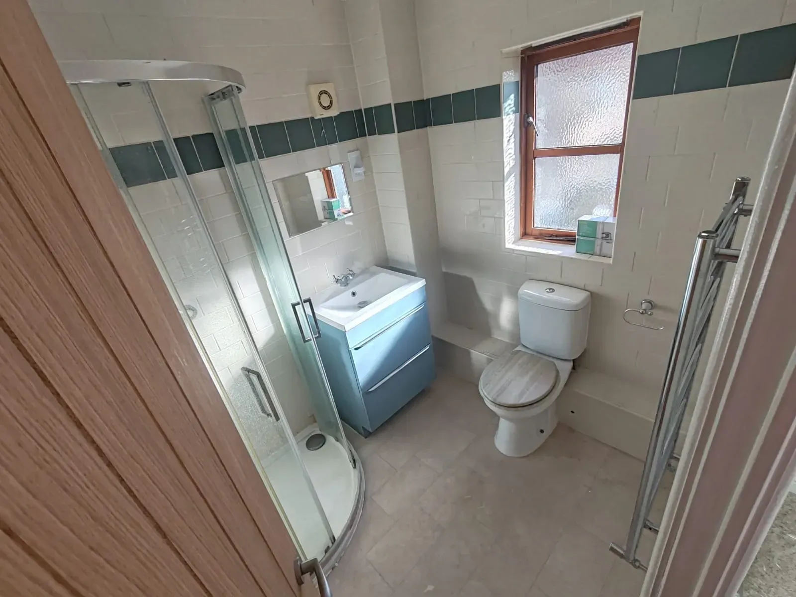 Unrenovated bathroom showcasing a toilet, sink, and shower in a standard arrangement.