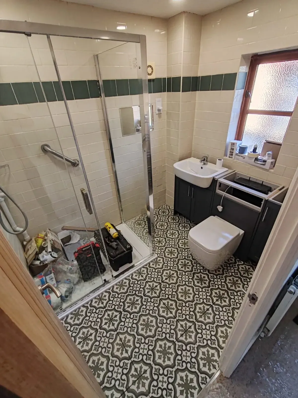 A well-lit bathroom showcasing a shower, toilet, and sink, designed with contemporary decor and tiled walls