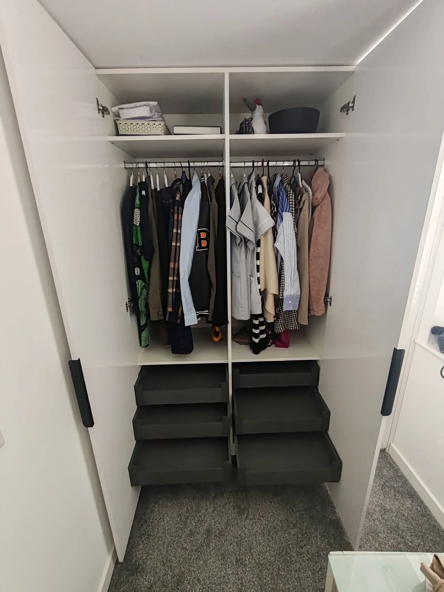 Stylish closet with neatly arranged clothes and shoes on shelves, demonstrating efficient storage solutions